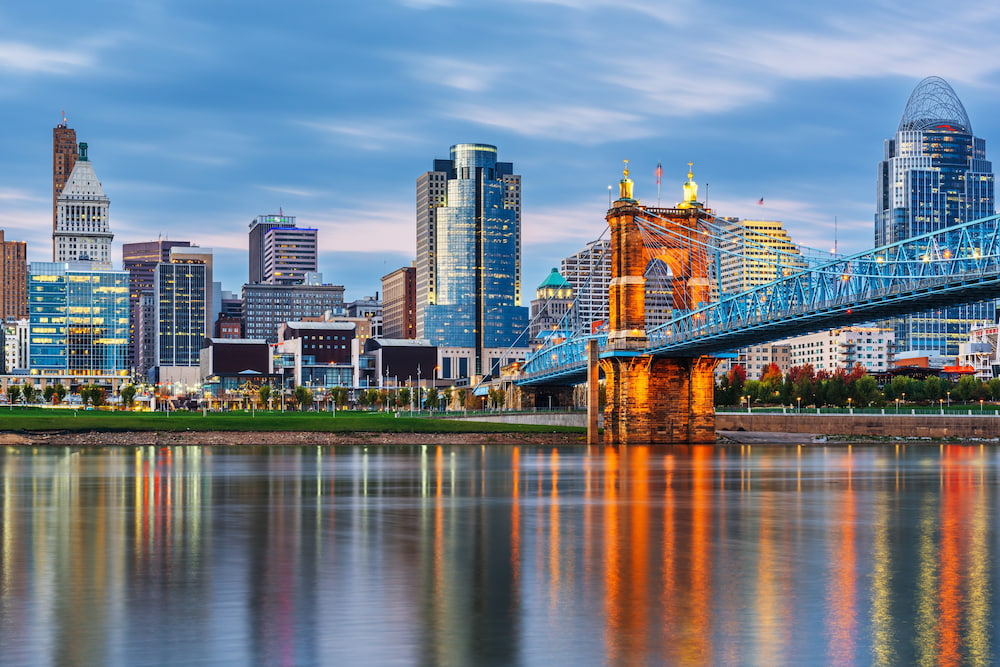 Cincinnati, Ohio, USA downtown skyline and bridge on the river at dusk.